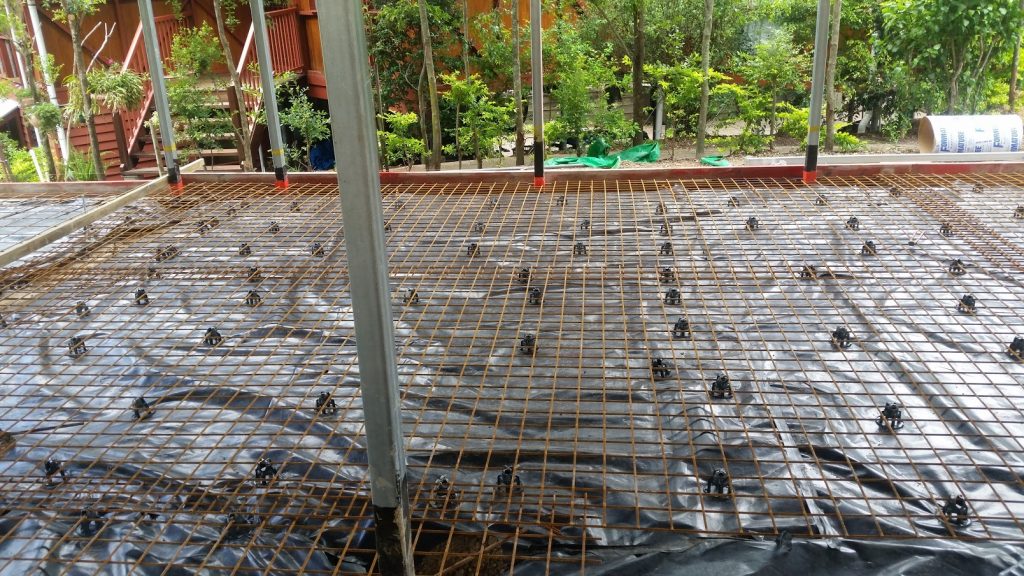 Picture of a concrete house slab before it is poured. The black sheet under the mesh is a vapour barrier.